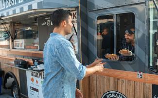 A person is handed food from a food truck