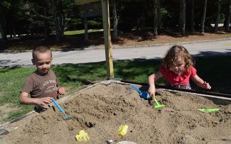 Two children digging in a sandbox